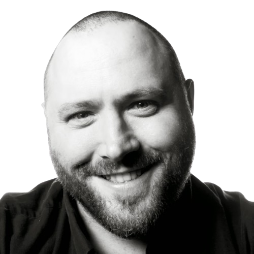 Mark Dickson, The Digital Learning Consultant – black and white headshot of Mark smiling, wearing a dark shirt.